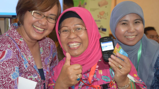 Women in Indonesia smile with the MyChoice family planning mobile app, SKATA.